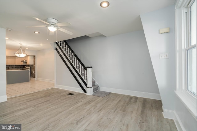 staircase featuring hardwood / wood-style floors and ceiling fan