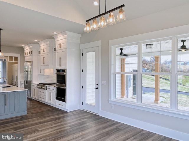 kitchen featuring sink, white cabinetry, and decorative light fixtures