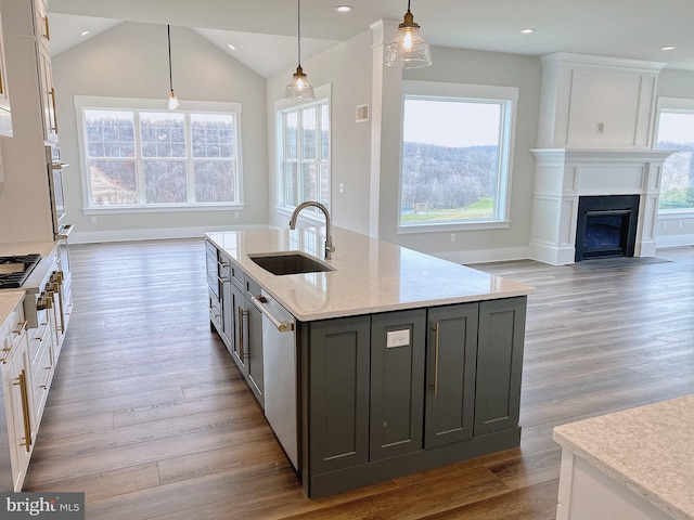 kitchen featuring light hardwood / wood-style floors, lofted ceiling, a wealth of natural light, and decorative light fixtures