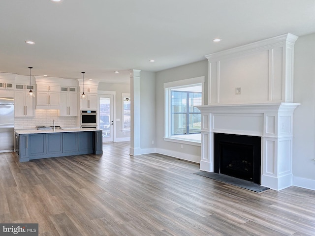 unfurnished living room with sink and light wood-type flooring