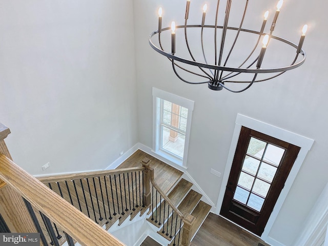 entrance foyer with an inviting chandelier, dark hardwood / wood-style floors, and a high ceiling