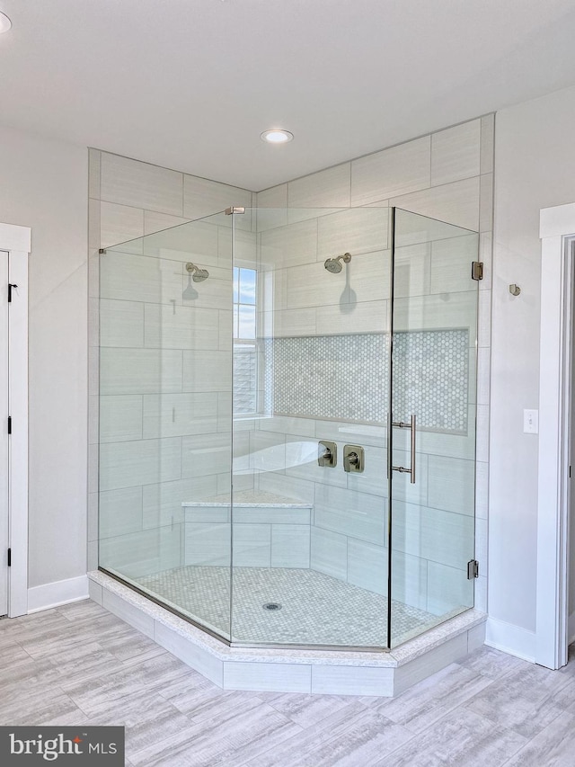 bathroom with an enclosed shower and hardwood / wood-style floors