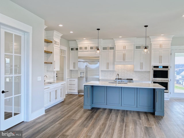 kitchen featuring sink, appliances with stainless steel finishes, decorative light fixtures, and white cabinetry