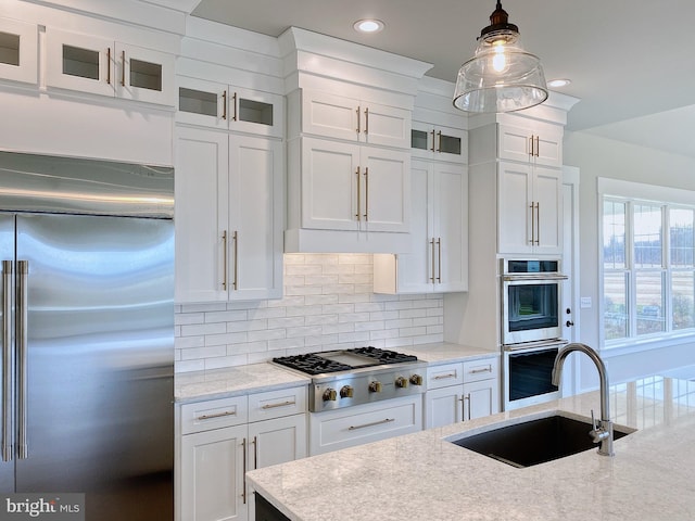 kitchen with white cabinets, stainless steel appliances, hanging light fixtures, and sink