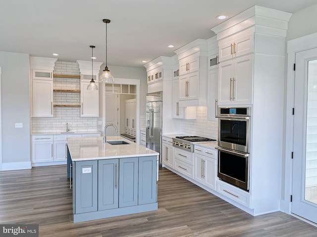 kitchen with appliances with stainless steel finishes, white cabinets, hanging light fixtures, and tasteful backsplash