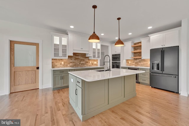 kitchen with sink, black appliances, white cabinets, and hanging light fixtures