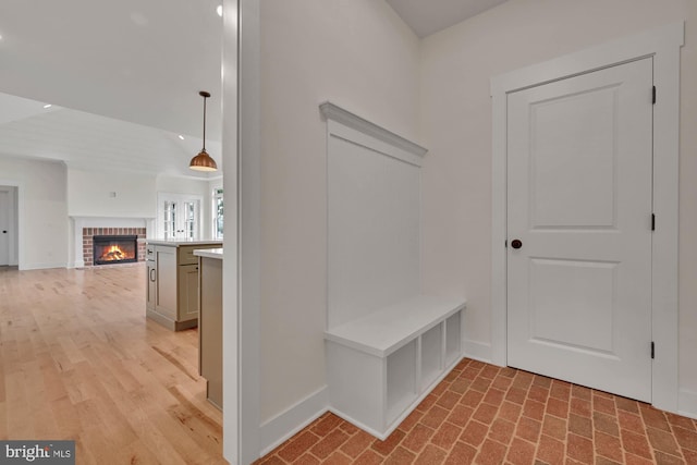 mudroom with light hardwood / wood-style floors and a fireplace