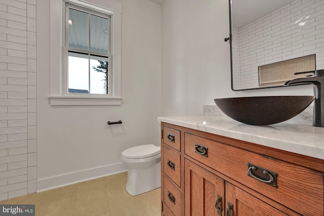 bathroom with vanity, toilet, and tile patterned floors