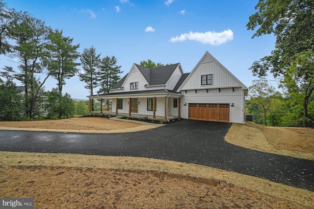 modern farmhouse style home featuring a porch and a garage