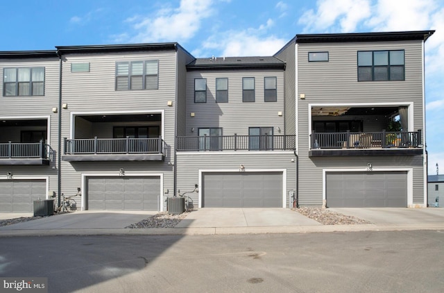 view of property with central AC unit, a garage, and a balcony