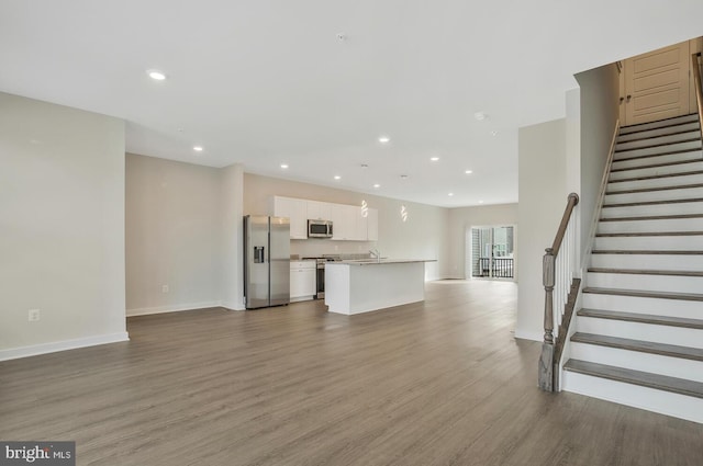 unfurnished living room featuring hardwood / wood-style flooring and sink