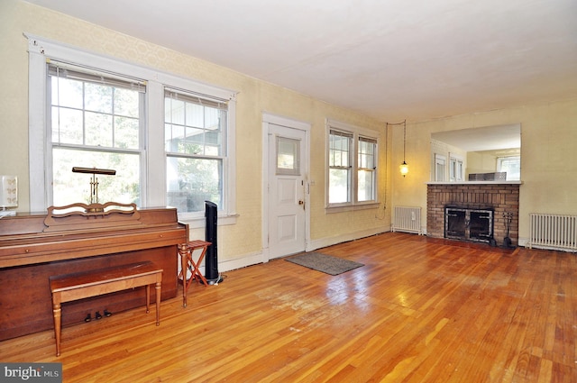 interior space featuring radiator, light wood-type flooring, and a fireplace