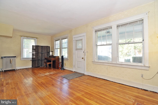 foyer entrance featuring hardwood / wood-style flooring and radiator heating unit