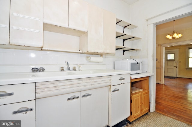 kitchen with light hardwood / wood-style flooring, decorative light fixtures, and white cabinets