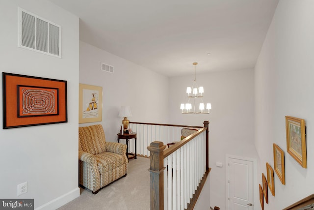 corridor featuring light carpet and a notable chandelier