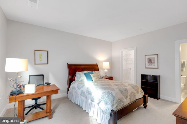 carpeted bedroom with ensuite bath and a spacious closet