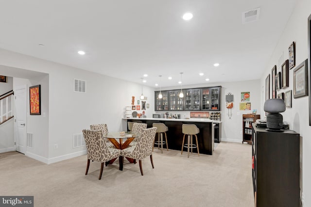 carpeted dining room with bar area