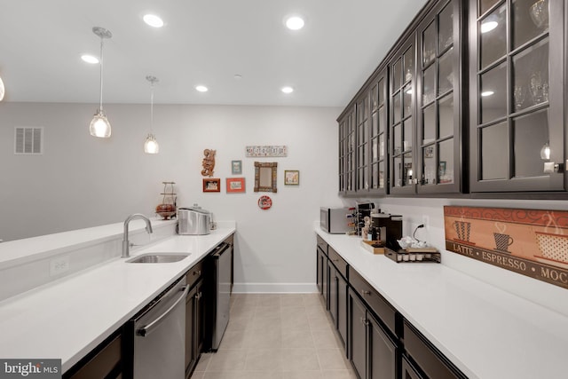 kitchen featuring sink, hanging light fixtures, light tile patterned floors, dark brown cabinets, and stainless steel appliances