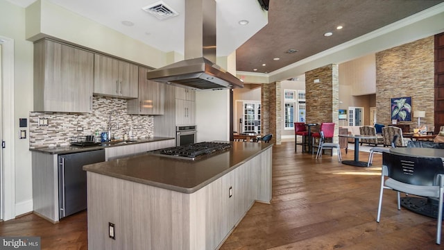 kitchen with stainless steel appliances, dark wood-type flooring, island exhaust hood, crown molding, and a kitchen island