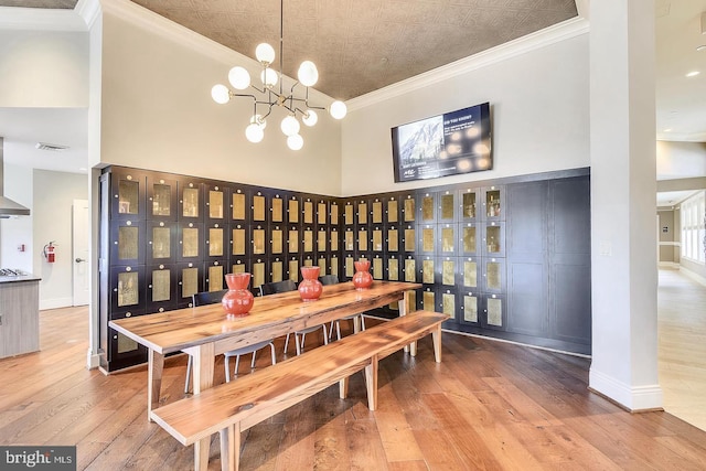 dining room featuring crown molding, a towering ceiling, and hardwood / wood-style flooring