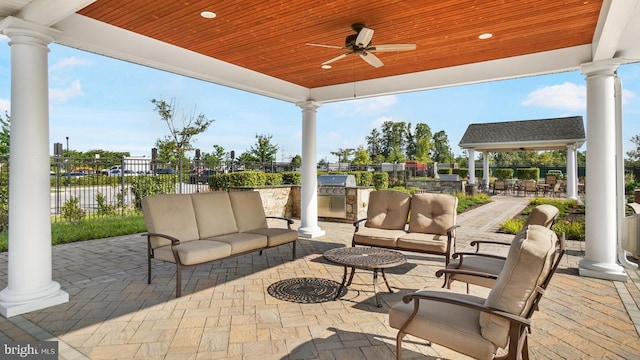 view of patio / terrace featuring ceiling fan, an outdoor kitchen, an outdoor living space, an outdoor bar, and a gazebo