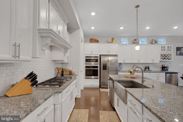 kitchen featuring stainless steel appliances, white cabinets, and pendant lighting