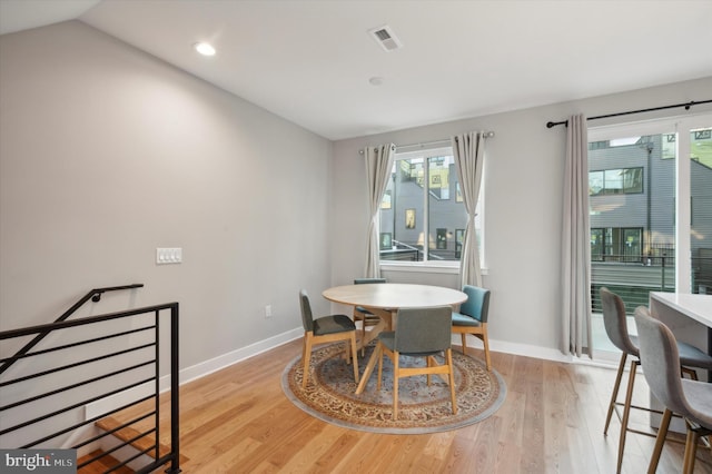 dining room featuring light hardwood / wood-style floors and lofted ceiling