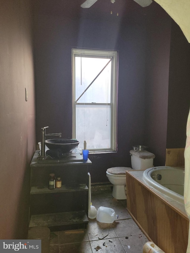 bathroom with toilet, a bath, tile patterned floors, and ceiling fan