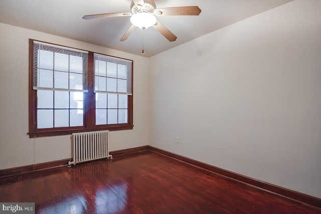 empty room featuring wood-type flooring, radiator, and ceiling fan