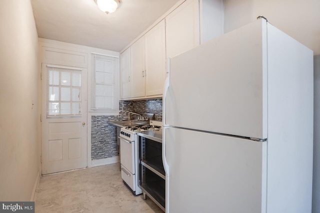 kitchen with sink, decorative backsplash, white cabinets, and white appliances