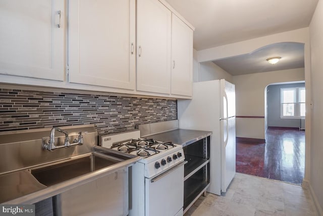 kitchen featuring white appliances, tasteful backsplash, sink, white cabinetry, and light hardwood / wood-style flooring