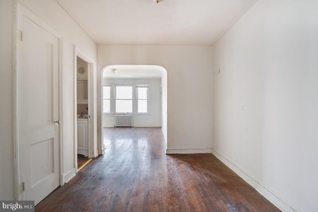 empty room featuring radiator and dark wood-type flooring