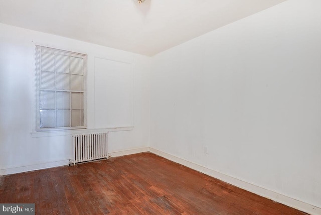 unfurnished room featuring hardwood / wood-style flooring and radiator heating unit