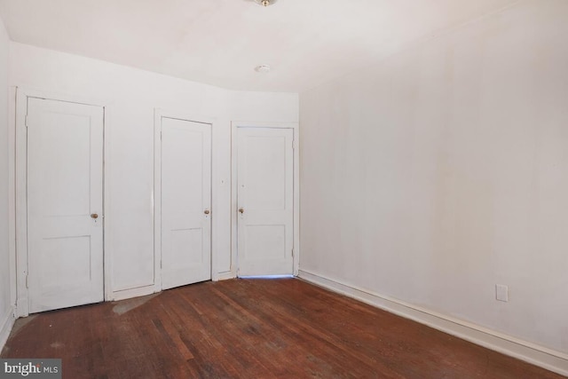 unfurnished bedroom with dark hardwood / wood-style floors