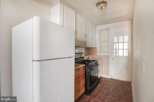 kitchen featuring white fridge, black gas range, tasteful backsplash, and dark parquet floors