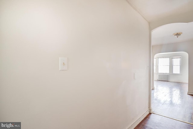 corridor featuring hardwood / wood-style floors and radiator