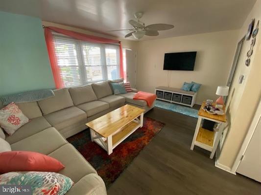 living room with ceiling fan and dark hardwood / wood-style flooring