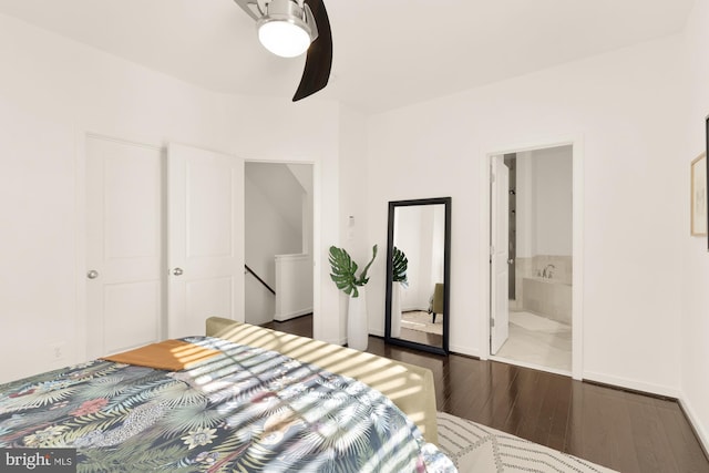 bedroom featuring ceiling fan, dark hardwood / wood-style floors, and connected bathroom