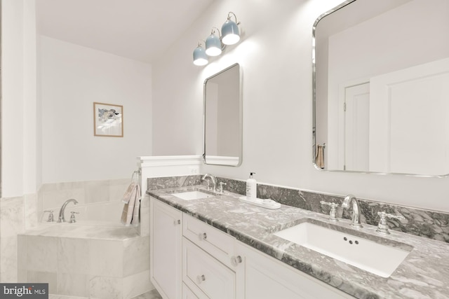 bathroom featuring tiled bath and vanity