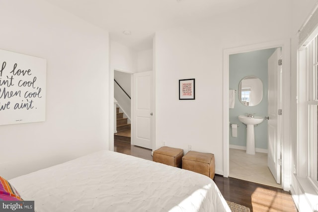 bedroom with dark hardwood / wood-style flooring and connected bathroom