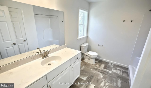 bathroom featuring a shower, vanity, and toilet