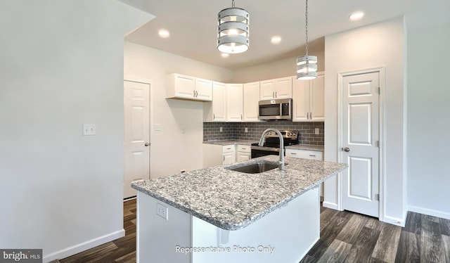 kitchen featuring light stone countertops, white cabinetry, a kitchen island with sink, and appliances with stainless steel finishes