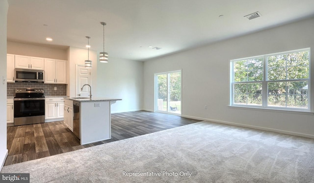 kitchen featuring appliances with stainless steel finishes, dark hardwood / wood-style flooring, white cabinetry, and a kitchen island with sink