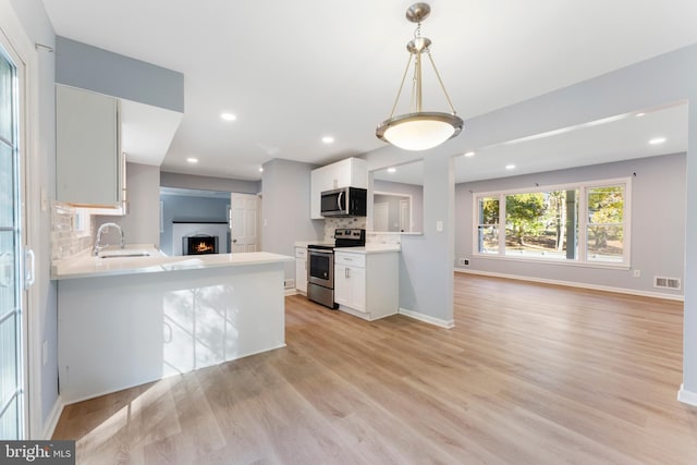 kitchen featuring stainless steel appliances, decorative backsplash, sink, and white cabinets