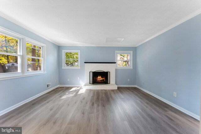 unfurnished living room featuring ornamental molding, a healthy amount of sunlight, and hardwood / wood-style flooring