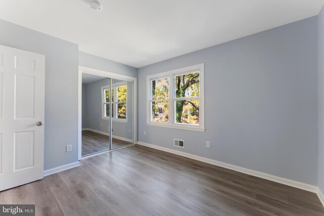 unfurnished bedroom featuring hardwood / wood-style floors and a closet