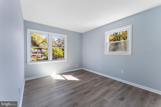 unfurnished room featuring a healthy amount of sunlight and hardwood / wood-style floors