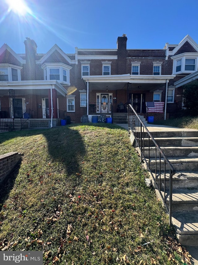 back of house featuring a porch and a yard