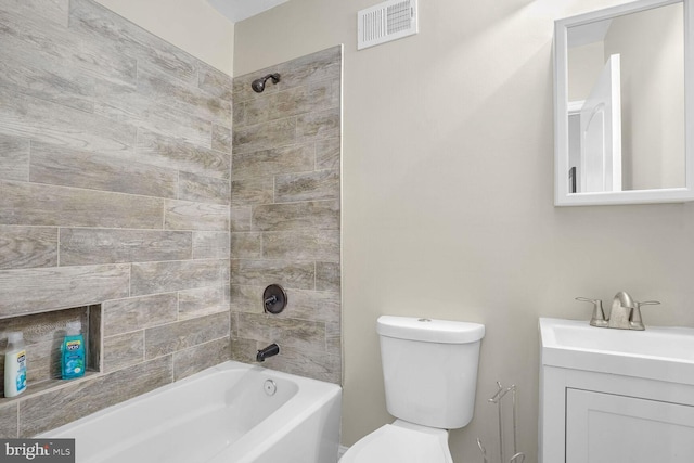 full bathroom with tiled shower / bath, vanity, and toilet