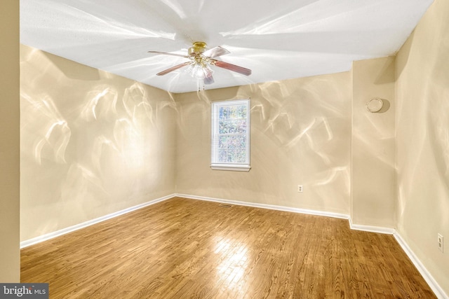 empty room with hardwood / wood-style flooring and ceiling fan